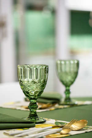 Dinner table setting idea with textured green glass goblets.の写真素材