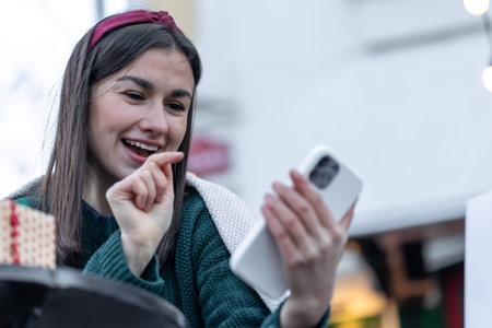 Attractive young woman uses smartphone, Christmas online shopping.
