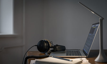 Workplace with headphones and laptop in the evening, copy space.の写真素材