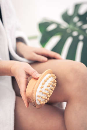 Close-up of anti-cellulite massage brush in female hands.の写真素材