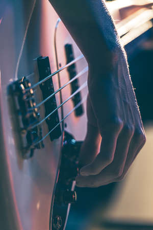 Close-up of a man playing the bass guitar.の写真素材
