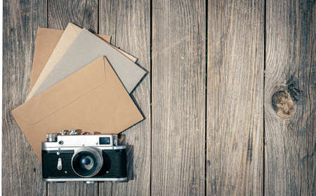Vintage retro camera and envelopes with letters on wooden background, flat lay.の写真素材