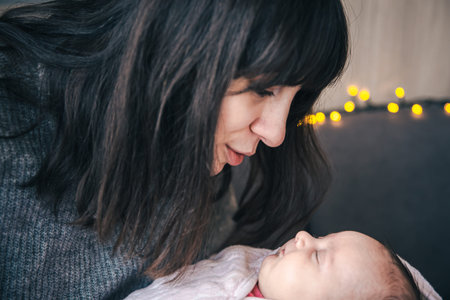 A young mother with a newborn baby girl in her arms.