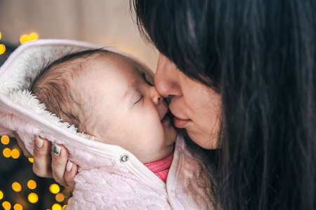 A young mother with a newborn baby girl in her arms.の写真素材