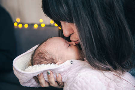 A young mother with a newborn baby girl in her arms.の写真素材