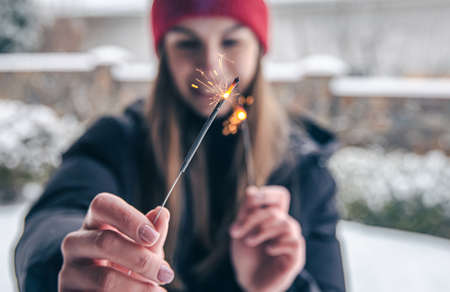 Close-up young woman holding sparklers in her hands.の写真素材