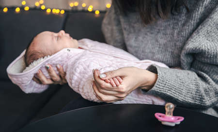 Mom holds the pen of her little newborn daughter.の写真素材