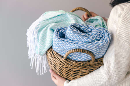 Textured plaids in a wicker basket on a gray background.の写真素材