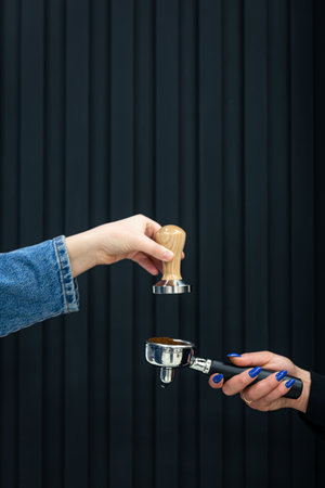 Female hands hold a holder with coffee and temperature on a black background.の写真素材