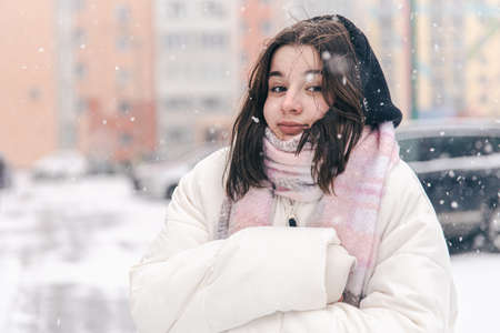 A teenage girl froze in snowy weather.の写真素材