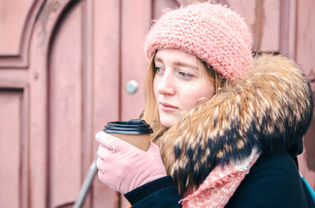 Young woman with a glass of hot drink in winter, close-up.の写真素材