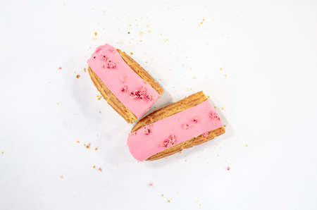 Eclair in pink glaze on a white background isolated.の写真素材