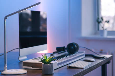 Computer, midi keyboard and headphones on the table, music creation concept.の写真素材