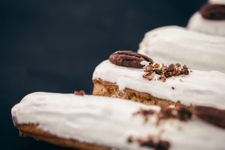 Close-up of eclairs in white glaze with pecans.の写真素材