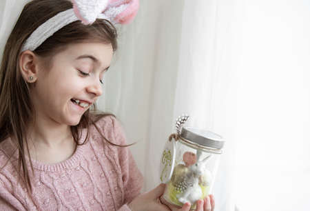 Easter background with a girl in bunny ears and decor, copy space.の写真素材