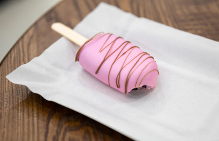 Mousse dessert in the form of popsicle ice cream covered with pink chocolate.