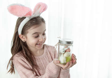 Easter background with a girl in bunny ears and decor, copy space.の写真素材