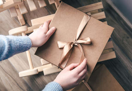 Beautiful box with a bow in female hands, top view.の写真素材