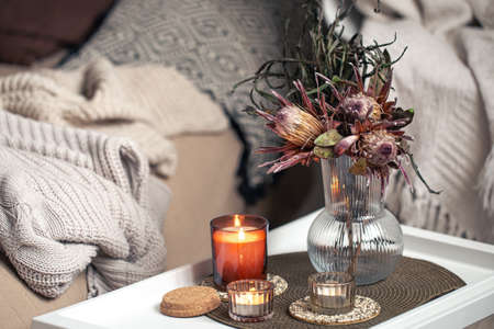 Home composition with a bouquet of protea flowers and candles.の写真素材