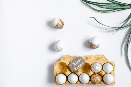 Easter background with decorative eggs tray isolated on white, flat lay.
