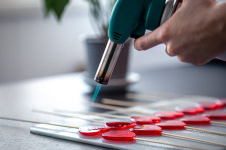 Close-up, the process of making heart-shaped lollipops.