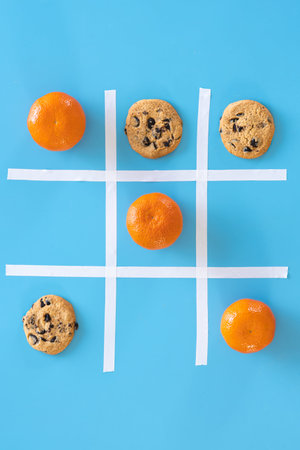 Cookies and tangerines on a blue background, flat lay.
