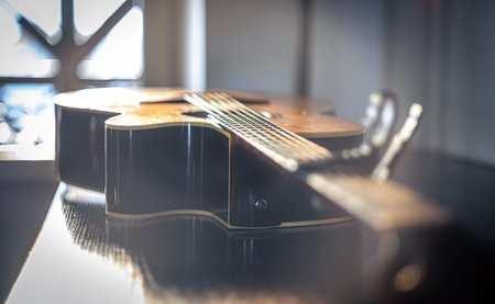 Close-up of an acoustic guitar on a blurred background.