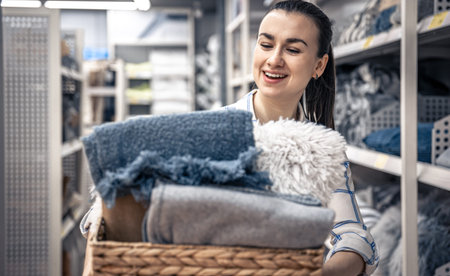 A young woman with a wicker basket full of blankets in a home improvement store.