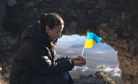 A young woman with the flag of Ukraine in her hands.