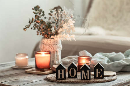 Close up decorative word home on blurred background with candles.の素材 [FY310183203267]