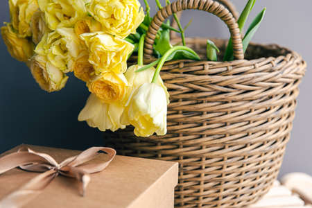 Basket with yellow flowers and gift box, copy space.の写真素材