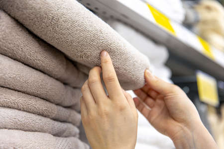 Close-up, a woman chooses a towel in a home goods store.の写真素材