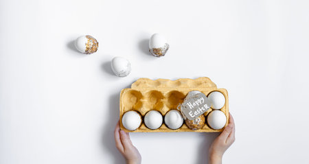 Easter background with decorative eggs tray isolated on white, flat lay.
