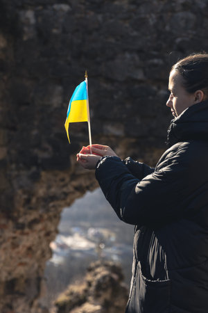 A young woman with the flag of Ukraine in her hands.