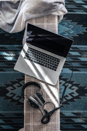 Laptop and headphones on the background of a rural carpet, top view.