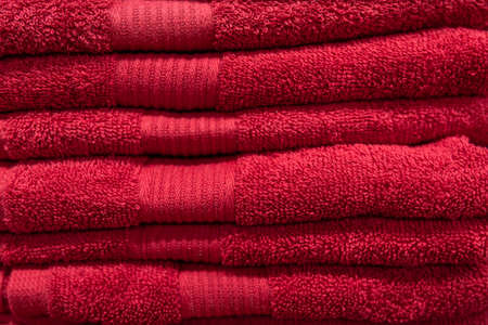 Textured red bath towels stacked close up.の写真素材