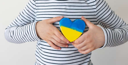 Heart painted in the colors of the flag of Ukraine in childrens hands.の写真素材