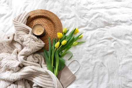 Cozy composition with flowers and candle on a white background, top view.の写真素材