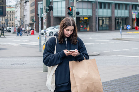 A young woman in the city on the street with a package, shopping concept.