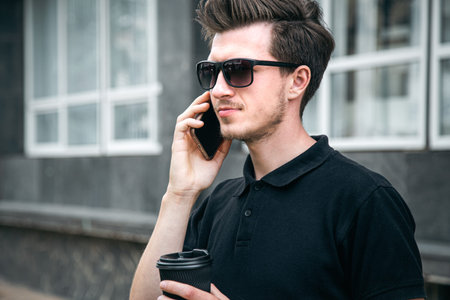 Young man in sunglasses is talking on a smartphone.