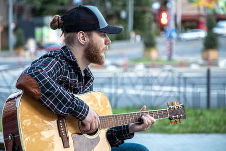 Male street musician plays the acoustic guitar.の写真素材