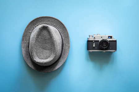 Hat and retro camera on a blue background, flat lay.の写真素材