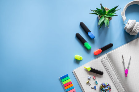 School supplies stationery on a blue background, copy space.