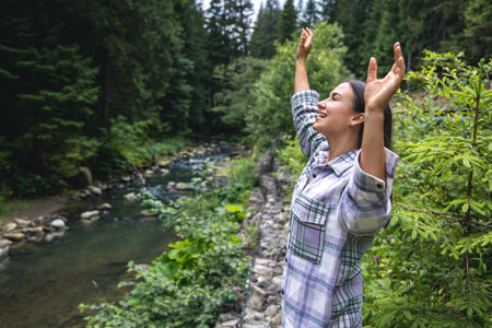 Happy young woman in the forest in the highlands near the river.