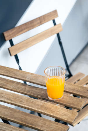 A glass of orange juice on a wooden table on the terrace.の写真素材