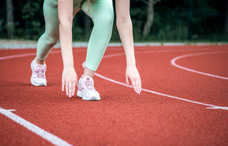 A young woman at the starting line in the stadium before the run.の写真素材