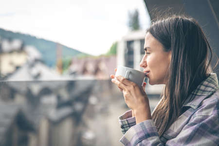 A woman drinking coffee on the balcony in the morning.の写真素材