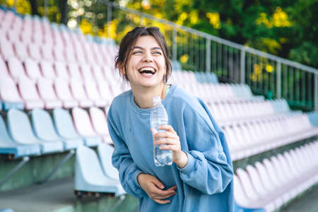Attractive young female athlete drinks water after a workout.の写真素材