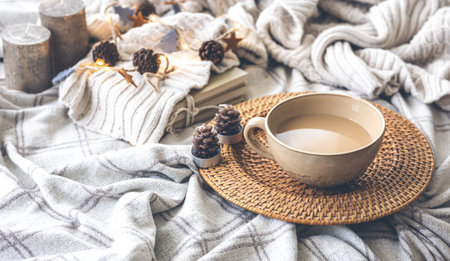 Cozy autumn composition with a big cup of coffee in bed.