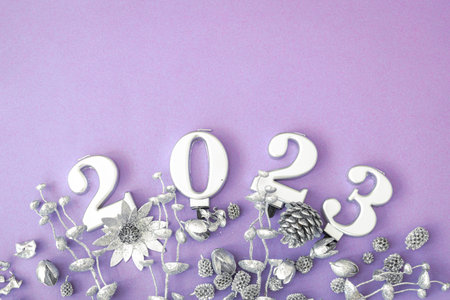 Lilac Christmas background with numbers 2023 and decor details, flat lay.